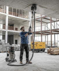 Contractor using Oztec ceiling grinder to prepare concrete ceiling for finishing work